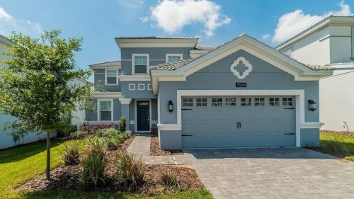 a large blue house with a garage at Villa at Champions Gate Resort in Orlando near Theme Parks with Private Pool, SPA & Movie Theater in Davenport