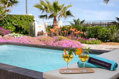 Dos copas de vino en una mesa junto a una piscina. en Villa Erika Beach House, en Malgrat de Mar
