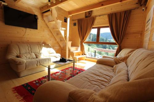 ein Wohnzimmer mit einem Sofa und einem großen Fenster in der Unterkunft Weekend house Lokve - Modern in Berane