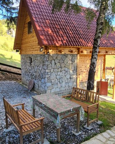 two benches and a table in front of a building at Weekend house Lokve - Modern in Berane
