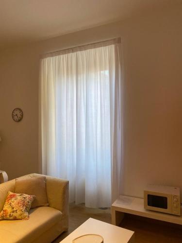 a living room with a couch and a white curtain at PALAZZO MARCHETTI in Ancona