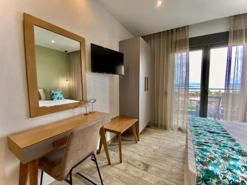 um quarto com uma secretária, uma cama e um espelho em THEA Luxury Apartments em Vourvourou