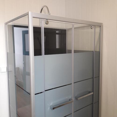 une vitrine avec des poignées argentées dans une pièce dans l'établissement Appartement paisible - cœur de ville, au Creusot