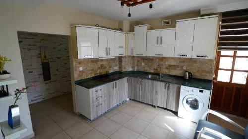 a kitchen with white cabinets and a washing machine at Arya Suits in Antalya