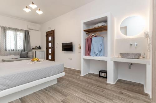 a white bedroom with a bed and a sink at Naxian Air in Agios Georgios