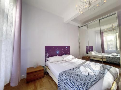 une chambre avec un grand lit et un miroir dans l'établissement Nestor&Jeeves - BEAUSOLEIL - Central - tres proche mer, à Nice
