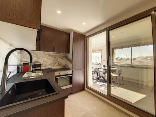 une cuisine avec un évier et une table avec des chaises dans l'établissement Nestor&Jeeves - BELLE ETOILE - Central - Premium, à Nice