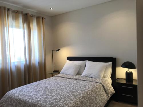 1 dormitorio con cama, lámpara y ventana en Beachfront Apartment With Sea View en Azurara