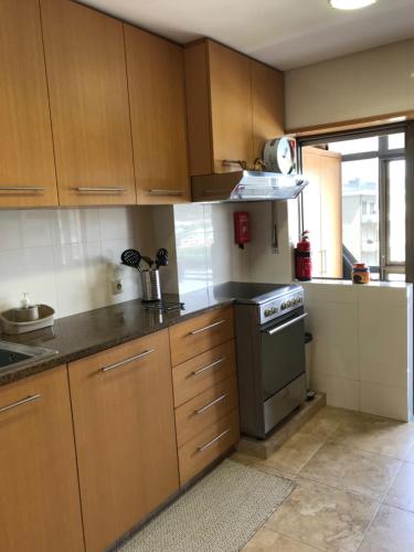 a kitchen with wooden cabinets and a stove top oven at Beachfront Apartment With Sea View in Azurara