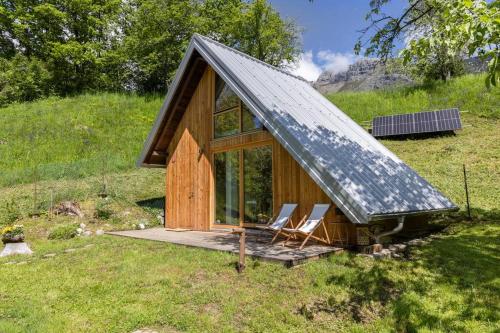 a cabin with two chairs and a pitched roof at Tiny Eko House Bovec in Bovec