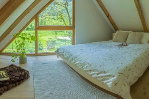 um quarto com uma cama e uma grande janela em Tiny Eko House Bovec em Bovec