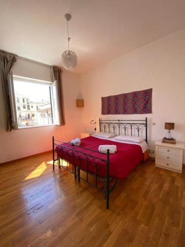 a bedroom with a bed with a red blanket at Sunny loft with terrace and Jacuzzi in the city centre in Palermo
