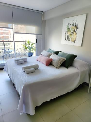 Una gran cama blanca con almohadas encima. en CDM Temporal 2, en Rosario