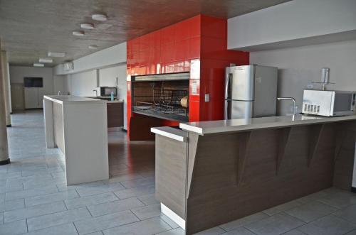 cocina grande con paredes rojas y electrodomésticos de acero inoxidable en CDM Temporal 2 en Rosario