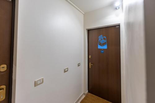 un pasillo con una puerta marrón y una señal en él en Studio La Chaise Bleue en Niza