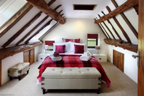 a bedroom with a large bed with red pillows at The Manor in Little Dean