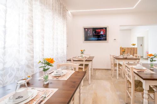 a dining room with tables and chairs and a tv at Aurosa Vacanze in Alliste