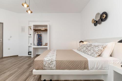 a white bedroom with a bed and white walls at Naxian Air in Agios Georgios