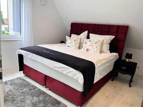 a bed with a red headboard in a bedroom at RelaxDays-Apartments in Gütersloh
