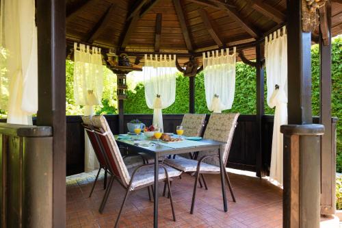 a table and chairs on a gazebo at Soba i Apartman Đula in Ogulin