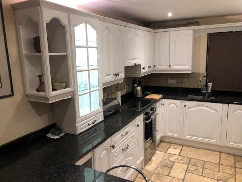 a kitchen with white cabinets and black counter tops at Stunning Sea view apartment absolute top quality 100s of 5 star reviews You will not be disappointed in Widows Row