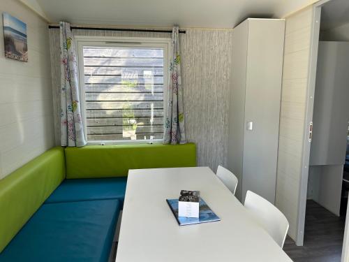 a room with a table and chairs and a window at Mobile home Grand Confort 30m² Modèle 1 in Arès
