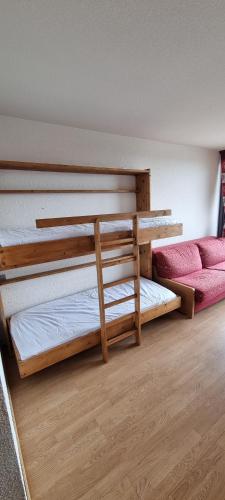 Cette chambre comprend 2 lits superposés et un canapé. dans l'établissement Studio la rosiere idéalement situé, à Montvalezan