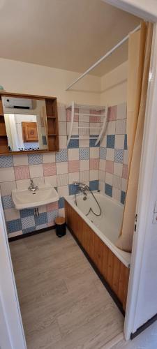 La salle de bains est pourvue d'une baignoire et d'un lavabo. dans l'établissement Studio la rosiere idéalement situé, à Montvalezan