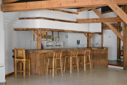 een kamer met een bar met houten krukken bij courfleurie reception in Bousse