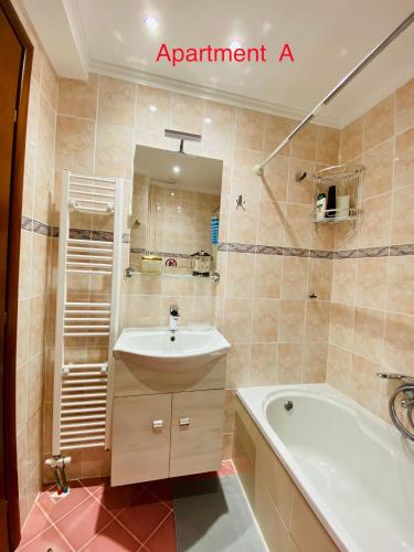 a bathroom with a tub and a sink and a bath tub at Side Sea View Apartment in Neoi Epivates