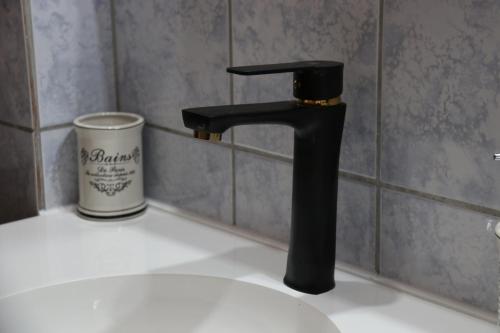 a black faucet on top of a bathroom sink at Apartman Eva in Jajce