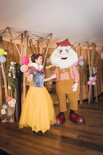 a woman standing next to a man in a costume at Biancaneve Family Hotel in Selva di Val Gardena