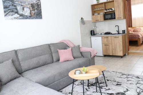 a living room with a gray couch and a table at Apartman Eva in Jajce