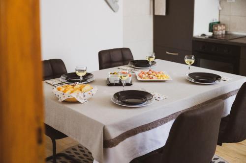 a table with glasses of wine and food on it at Soba i Apartman Đula in Ogulin