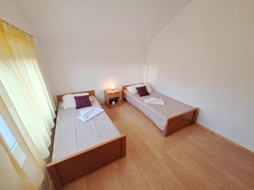 2 camas en una habitación pequeña con ventana en Apartman Lara, en Pašman