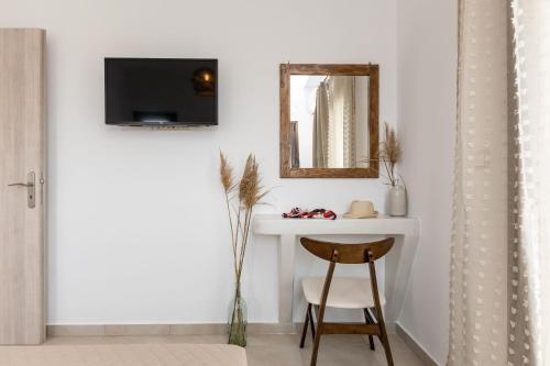 a room with a table and a mirror and a stool at Naxian Air in Agios Georgios