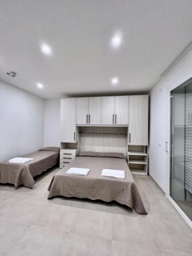 twee bedden in een grote kamer met witte muren bij Residence TERRAMARE in Lido di Jesolo