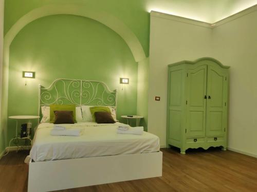 een slaapkamer met een groot bed en een groene muur bij CentroCittà Next in Catania