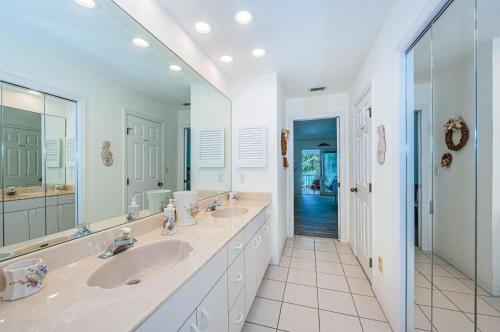 a bathroom with two sinks and a large mirror at Vista Mar in St Pete Beach