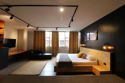 554 Apartments في كالي: غرفة نوم بسرير واريكة وتلفزيون
