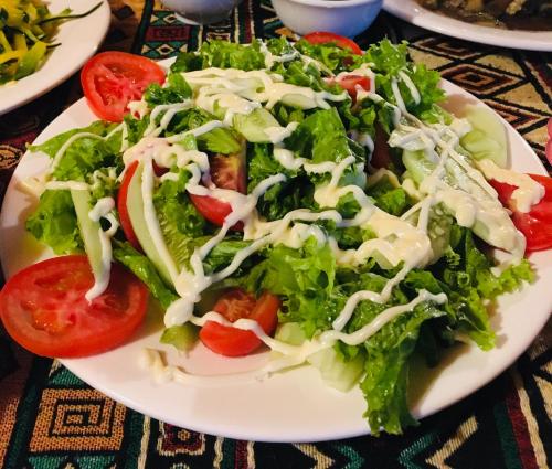 a plate of salad with tomatoes on a table at Sapa Guide Homestay & Trekking in Lao Cai