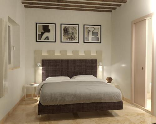 a bedroom with a large bed with four pictures on the wall at Torre del Fuggisole in Siena