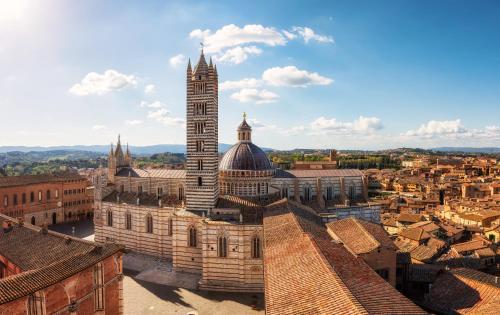 uma vista aérea de um edifício com uma torre de relógio em Torre del Fuggisole em Siena