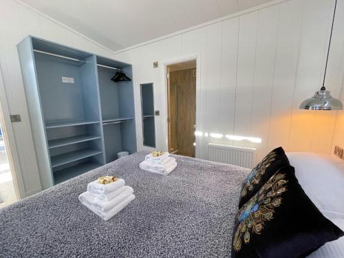a bedroom with towels sitting on a bed at Gorgeous Lake Lodge with HTub Outstanding Views in Annan
