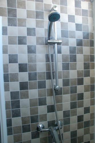 a shower in a bathroom with black and white tiles at El Campanario in Chiclana de la Frontera