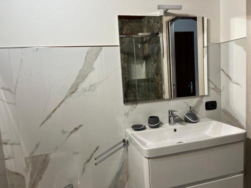 a white bathroom with a sink and a mirror at B&B SouthItaly in Busto Arsizio