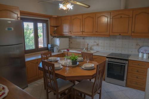 卡蘭巴卡的住宿－Villa Nefeli，厨房配有桌椅和冰箱。