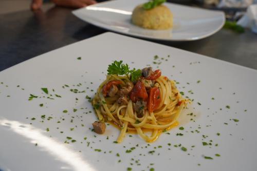 a white plate with pasta on a table at Hotel Albatros in Ischia