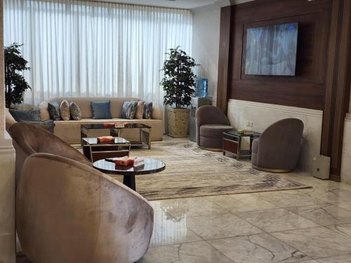 a living room with a couch and chairs and tables at شركة اس مسكن الفندقية in Dammam