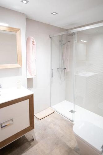 a white bathroom with a shower and a toilet at Apartamento playa Castellón in Grao de Castellón